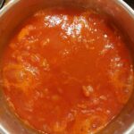 Red tomato soup boiling in a silver pot