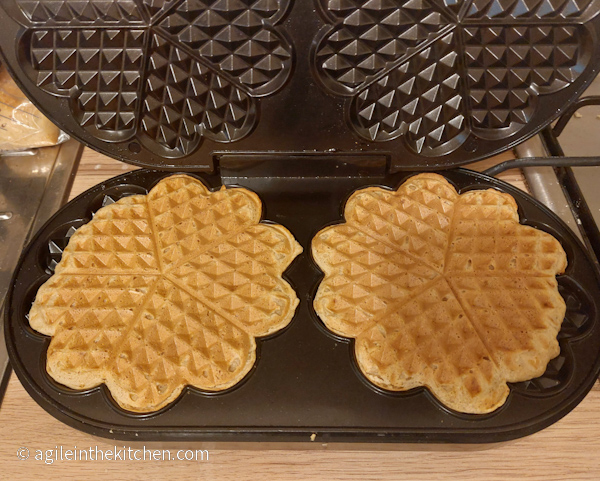 Two waffles cooked on a waffle maker