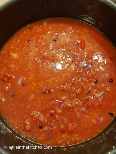 Tomato sauce cooking together in a pan.