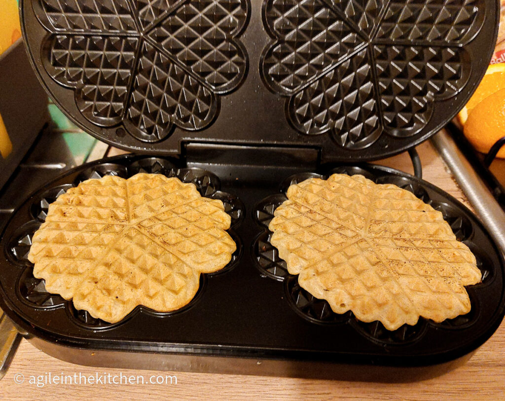 Two waffles baked in a waffle maker until golden brown