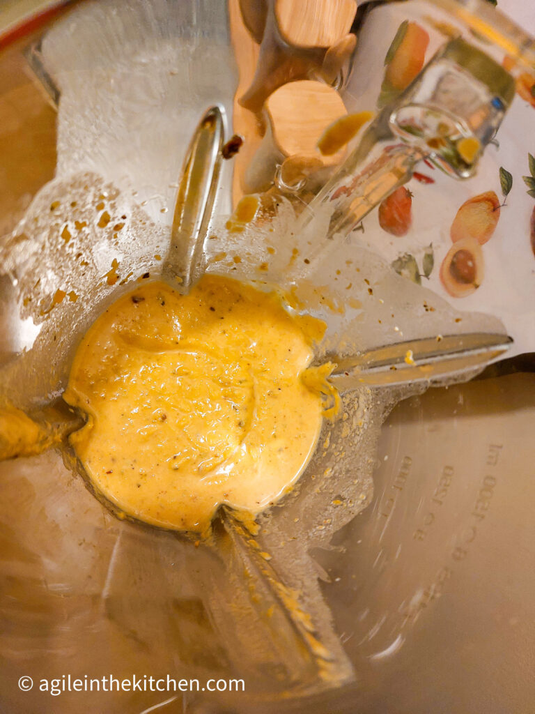 Photo taken from above looking into a standing mixer, with roasted butternut squash pure