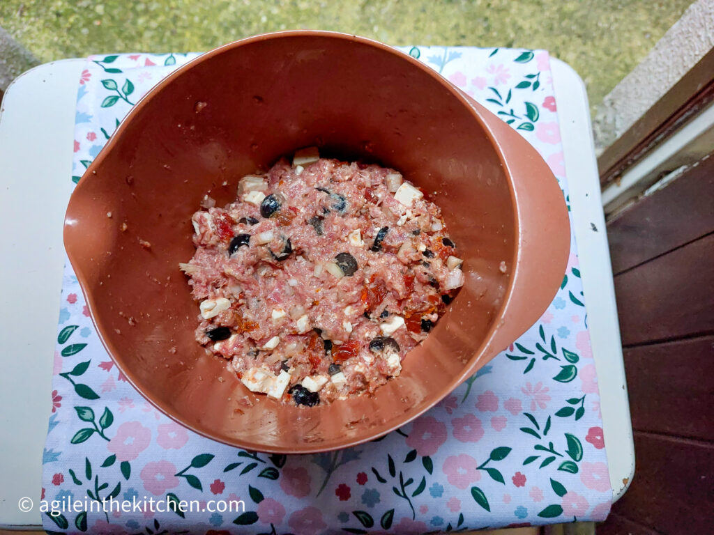 Taken from above, a bowl with Mediterranean mice meat on a white background with a tablecloth with flowers.