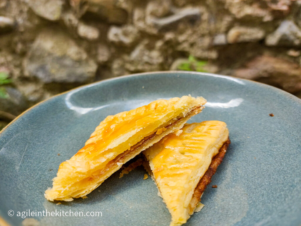 On a blue plate with a cinnamon rectangle cut in two triangles one half on top of the other.