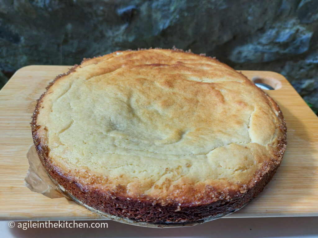 On a wooden cutting board, a white chocolate cake