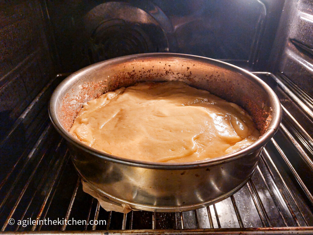 A photo taken from the oven, a white chocolate cake in its spring form ready to bake.