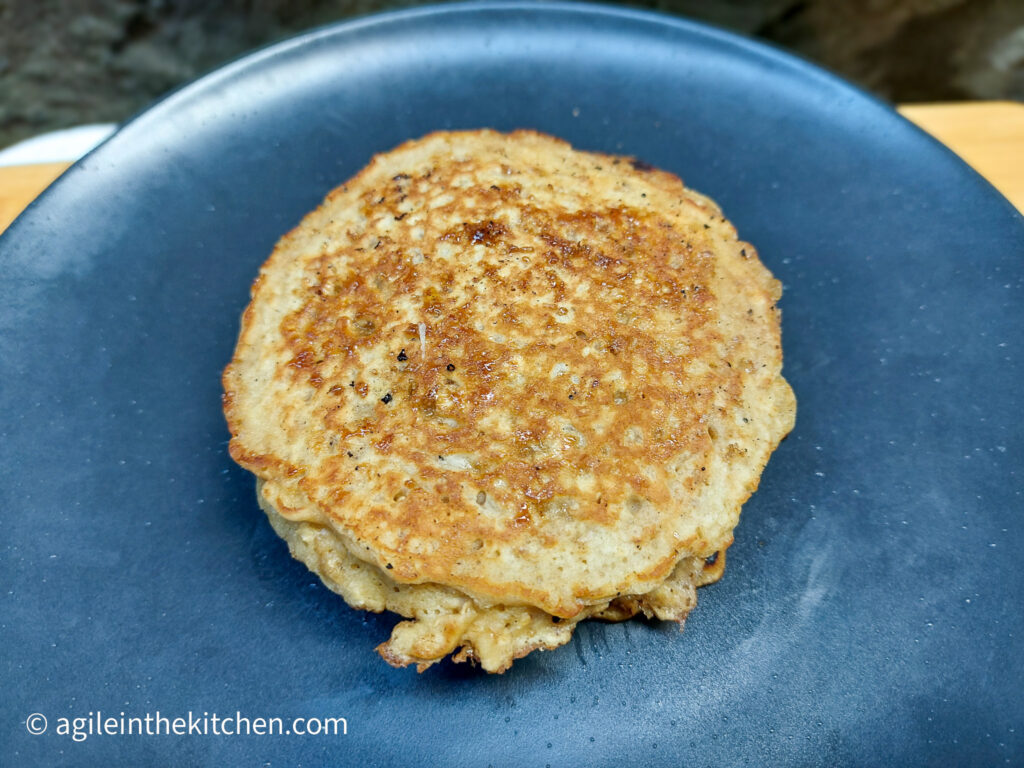 On a blue matte plate, a oat and brown sugar pancake.